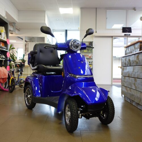 blauwe scootmobiel met spiegels in de showroom van puramobi