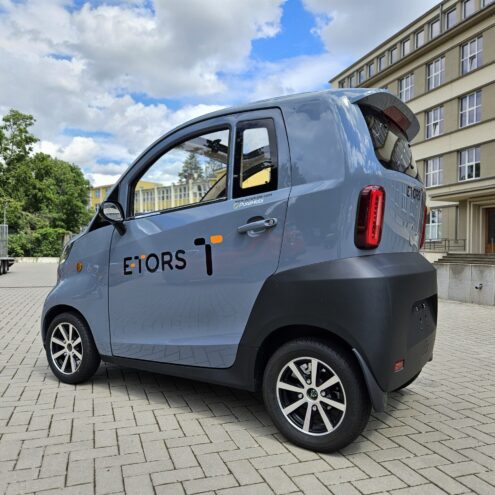 een grijze etors voertuig die buiten staat met puramobi bestickering