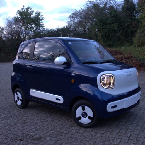 etors city wit blauwe brommobiel zijvooraanzicht die buiten staat op een parkeerplaats puramobi