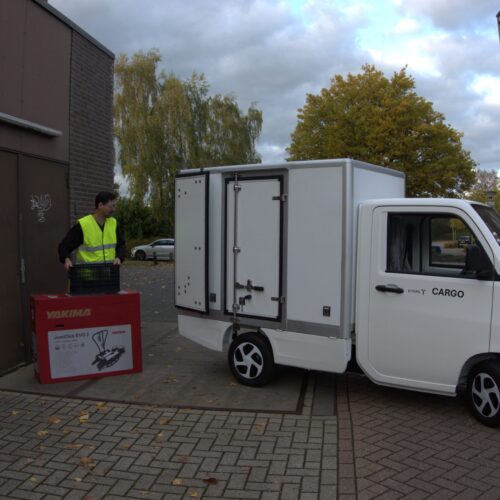 etors tc.02 zijaanzicht buiten opgesteld met een medewerker die het voertuig inlaad met een veiligheids hesje puramobi